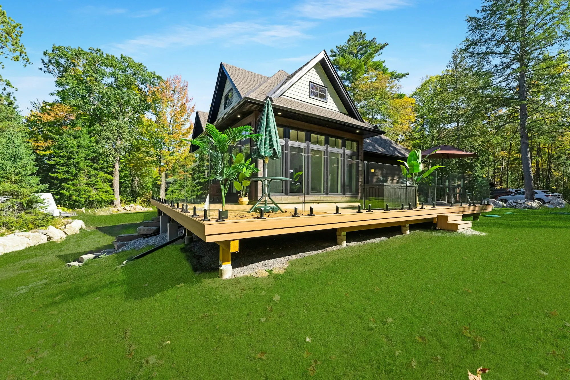 Detached dwelling with a wraparound deck on a grassy lot