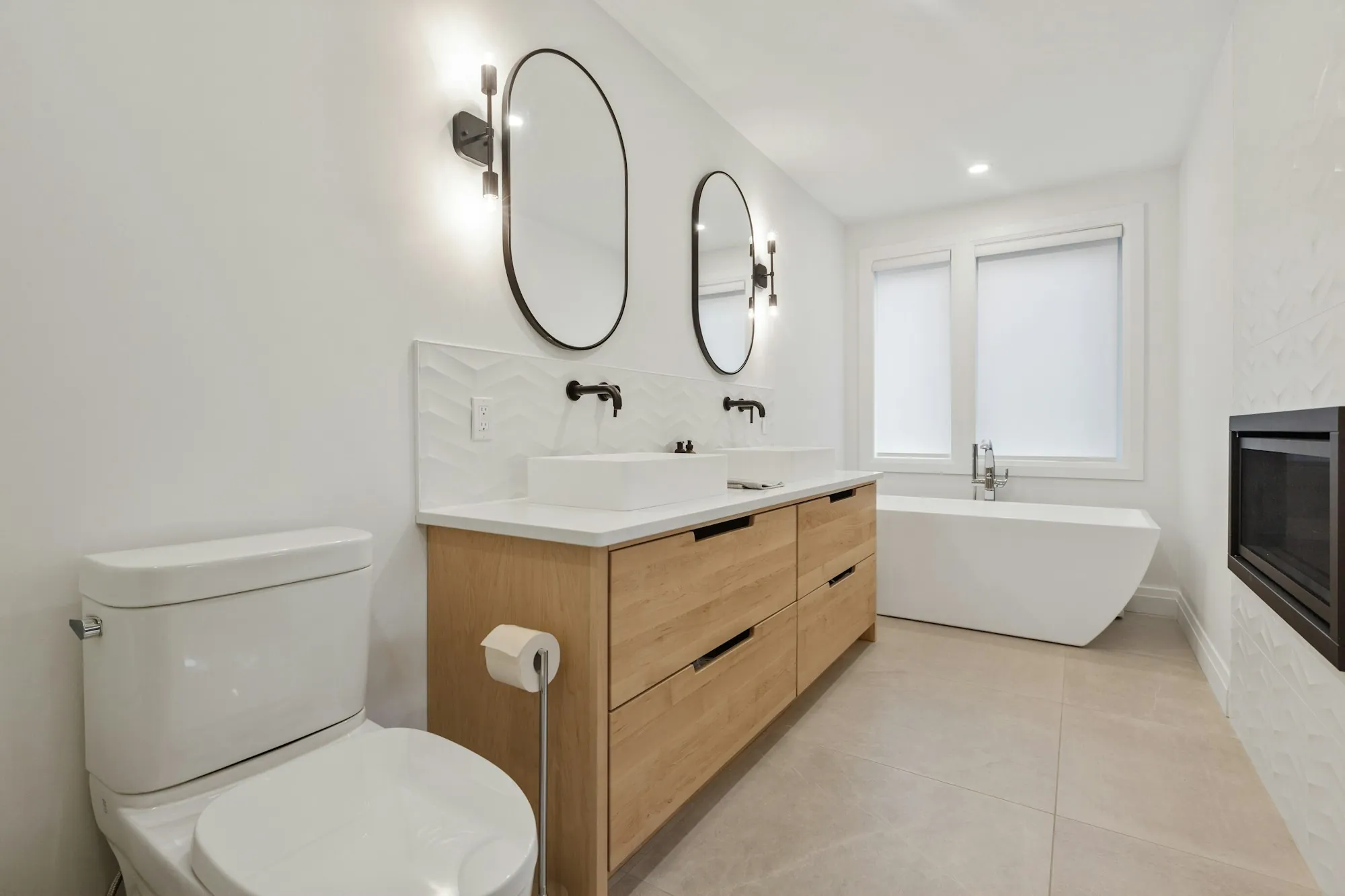 Remodeled bathroom with a wood vanity and freestanding tub